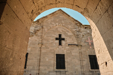 Fototapeta na wymiar Church and cross, church photo from arch type gate