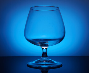 transparent glass goblet on blue background
