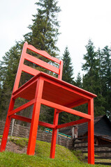 a large red chair. giant wooden chair. high status concept