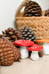 Handmade clay toadstools surrounded with pine cones background