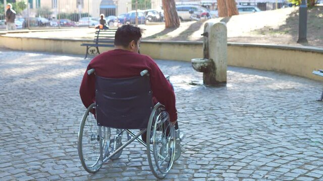 disability, paraplegia - young man with physical disability on wheelchair