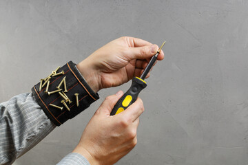 Tools magnetic bracelet on wrist with screws and screwdriver in person hands, close-up with copy...