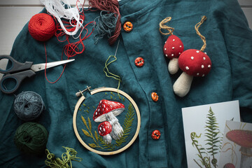 Flat lay with handmade fly agaric mushroom embroidery on dress