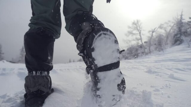 Hiker walking up climbing snow mountains. Snow walking hiker hiking in winter. Active lifestyle mountain climbing winter. travel in winter concept