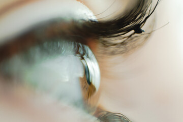 Imagen de un ojo marrón tierra de una chica con máscara de pestañas en un plano detalle casi...