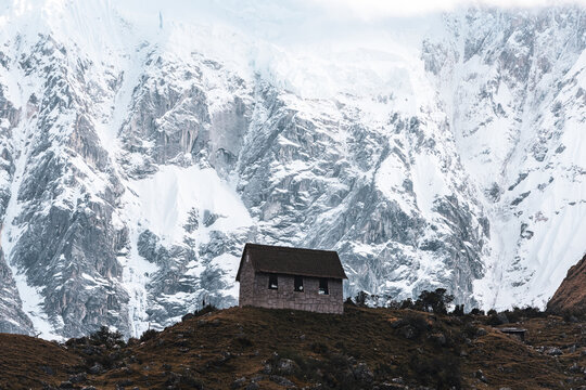 Epic backdrop of mount salkantay in the Peruvian andes with little mountain hut