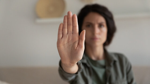 Worried concerned young woman showing palm, making hand stop denial gesture, expressing prohibition, refusal, fighting for equal rights against domestic violence, abuse, discrimination, bullying
