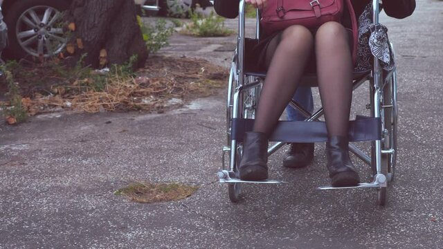 paraplegia, disability - woman using a wheelchair accompanied by a friend  