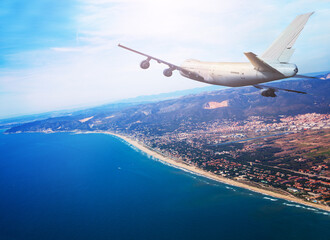 Fototapeta na wymiar Big jet airplane fly over Mediterranean coast