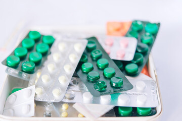 bunch of medical pills in white, pink, green and other colors. Tablets in plastic packaging. Health care and medicine concept. Pharmaceutical industry concept.