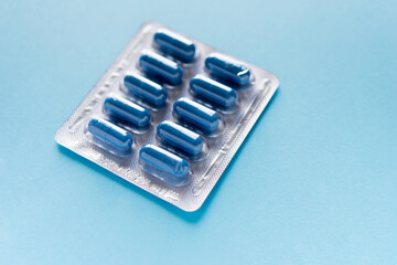 blister with pills, capsules of blue color on a blue background	