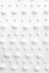 Many white pills on a white background. Health.