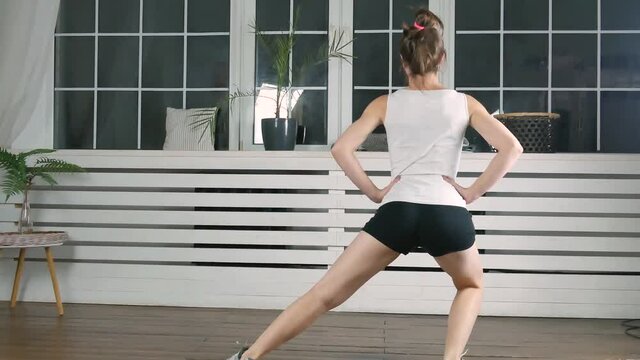 4k footage. Women doing squats exercise at home. Fitness girl doing sport workout in living room