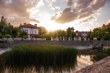 Panoramic view of the cottage village by the pond with green reeds at sunset. Life outside the city