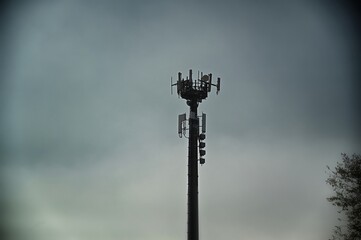 Fototapeta na wymiar telecommunications antennas tower silhouette under dull sky