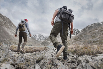 Two hikers or tourists walks in mountains