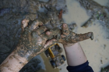 children's hands playing in the mud