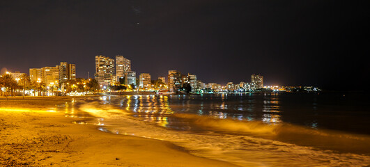 Fototapeta premium Playa de la Albufereta en Alicante vista por la noche, iluminada con luces de farolas y edifcios