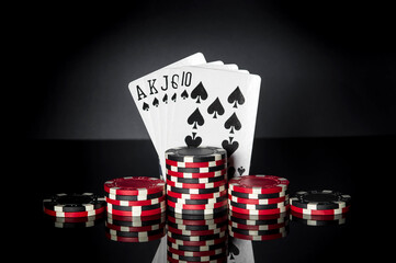 Poker game with royal flush combination. Chips and cards on black table. Successful and win