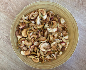 Dried apples in a plate close-up. Dried fruits from apples are in a wooden plate