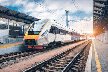 High speed train on the railway station at sunset - 464739706