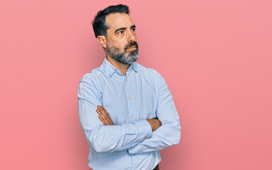 Middle aged man with beard wearing business shirt looking to the side with arms crossed convinced...