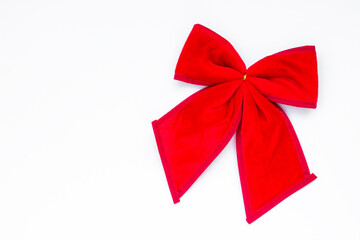 Christmas bow made of red fabric on white surface with copy space