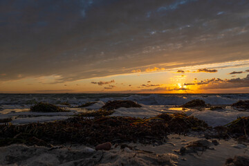 Obraz premium Sunset on a sandy beach. Ground-level shot. Inbserl Fehmarn, Germany
