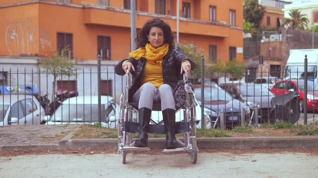 paraplegia, disability - young woman using wheelchair stares at camera