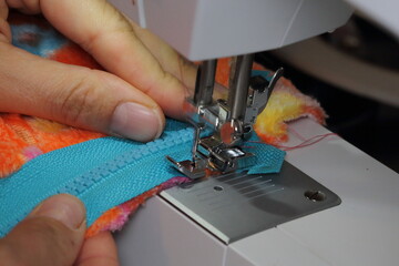 female hands sew on a sewing machine
