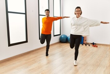 Fototapeta na wymiar Young hispanic sporty couple smiling happy training at sport center.