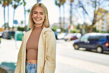 Fototapeta premium Young blonde girl smiling happy standing at the city.