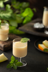 Melon cocktail with mint leaves,honey and ice with fresh melon on background and green summer plants.Detox,healthy drink.