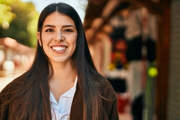 Young hispanic woman smiling happy standing at the city.