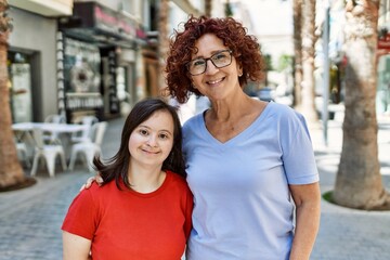 Mature mother and down syndorme daughter smiling happy and friendly outdoors © Krakenimages.com