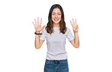 Young beautiful woman wearing casual white t shirt showing and pointing up with fingers number eight while smiling confident and happy.