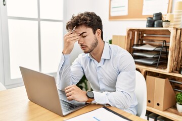 Young hispanic businessman overworked working at the office.