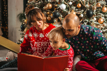 Fototapeta na wymiar Christmas night, beautiful family reading a book