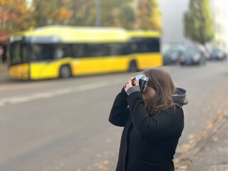 A girl walking around Berlin taking pictures of sights with an old film camera