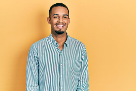 Young african american man wearing casual clothes looking positive and happy standing and smiling with a confident smile showing teeth