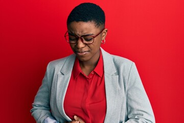 Young african american woman wearing business jacket and glasses with hand on stomach because indigestion, painful illness feeling unwell. ache concept.