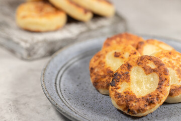 Curd fritters cooking at home, Cottage cheese pancakes with shape of heart, selective focus