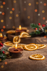 Christmas decoration, candle lights and dried orange, bokeh Christmas lights background with selective focus
