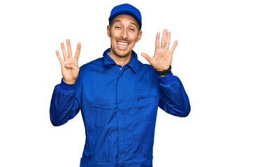 Bald man with beard wearing builder jumpsuit uniform showing and pointing up with fingers number...
