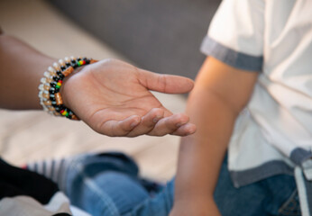 Manos de adolescente y un niño, demostrando su cariño de hermanos.