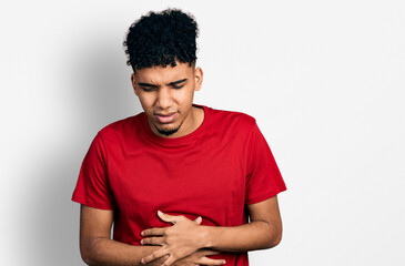 Young african american man wearing casual red t shirt with hand on stomach because indigestion, painful illness feeling unwell. ache concept.