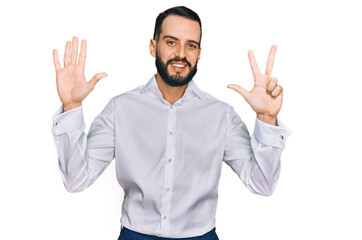 Naklejka premium Young man with beard wearing business shirt showing and pointing up with fingers number eight while smiling confident and happy.