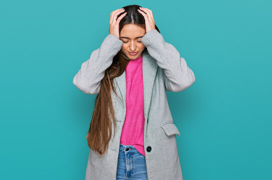 Young hispanic girl wearing business clothes suffering from headache desperate and stressed because pain and migraine. hands on head.