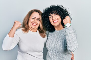 Middle east mother and daughter wearing casual clothes very happy and excited doing winner gesture with arms raised, smiling and screaming for success. celebration concept.