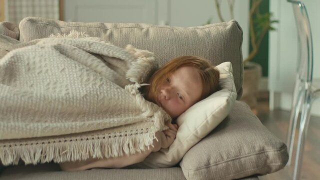 The Depressed Red-haired Girl is Sad Alone in the Living Room of the House. Mental Health Concepts, Bullying, Depression, and Anxiety. Mental Health.